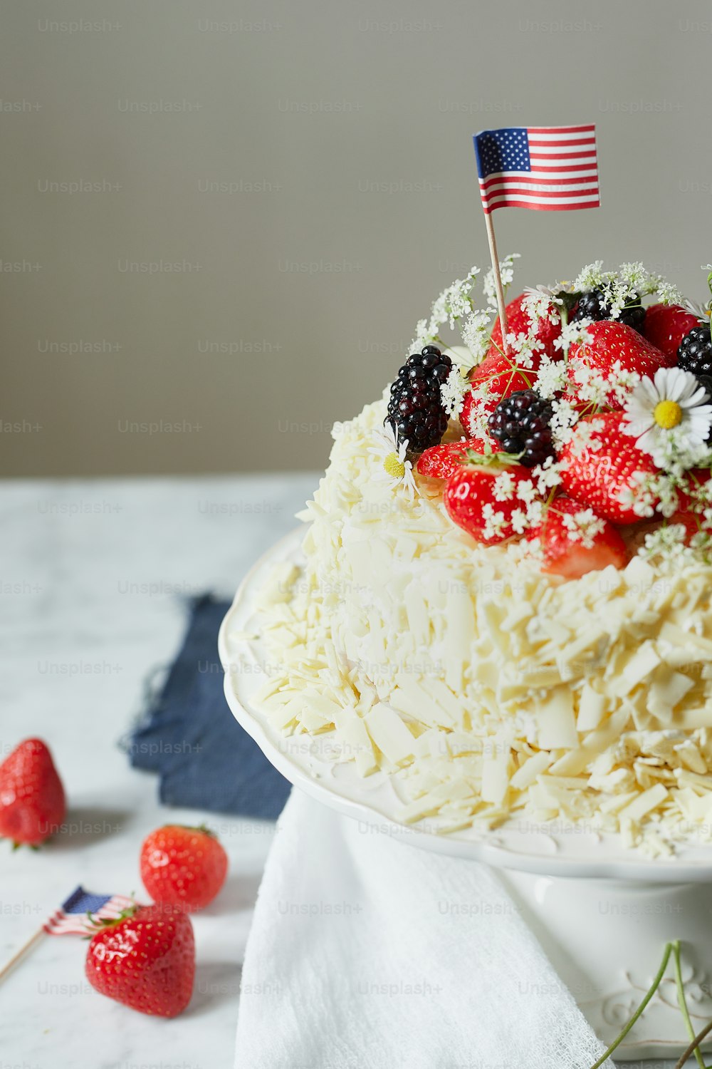 a cake with strawberries, strawberries, and daisies on top of it
