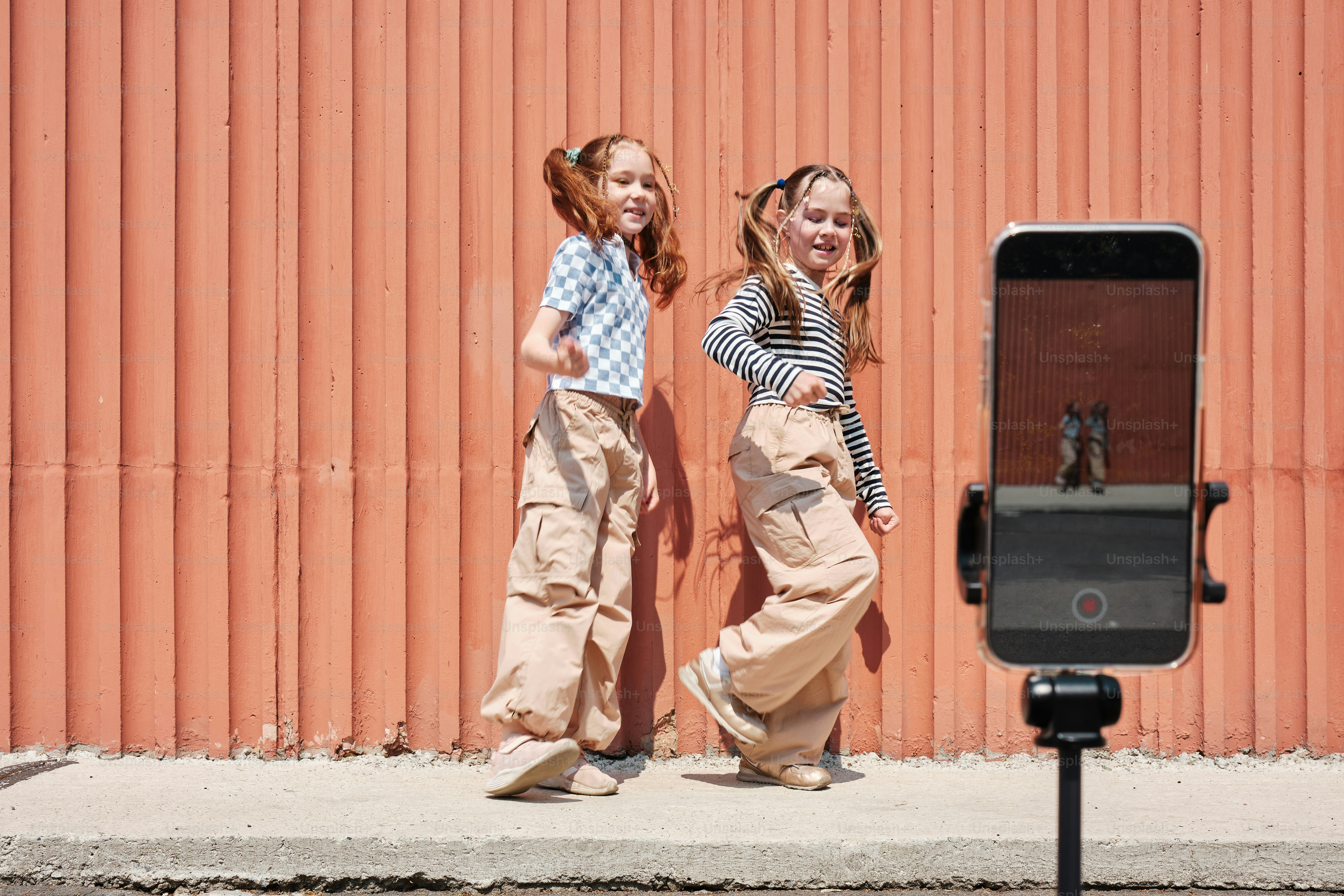 two young girls dancing in front of a camera