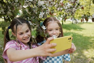 duas jovens tirando uma foto com um celular