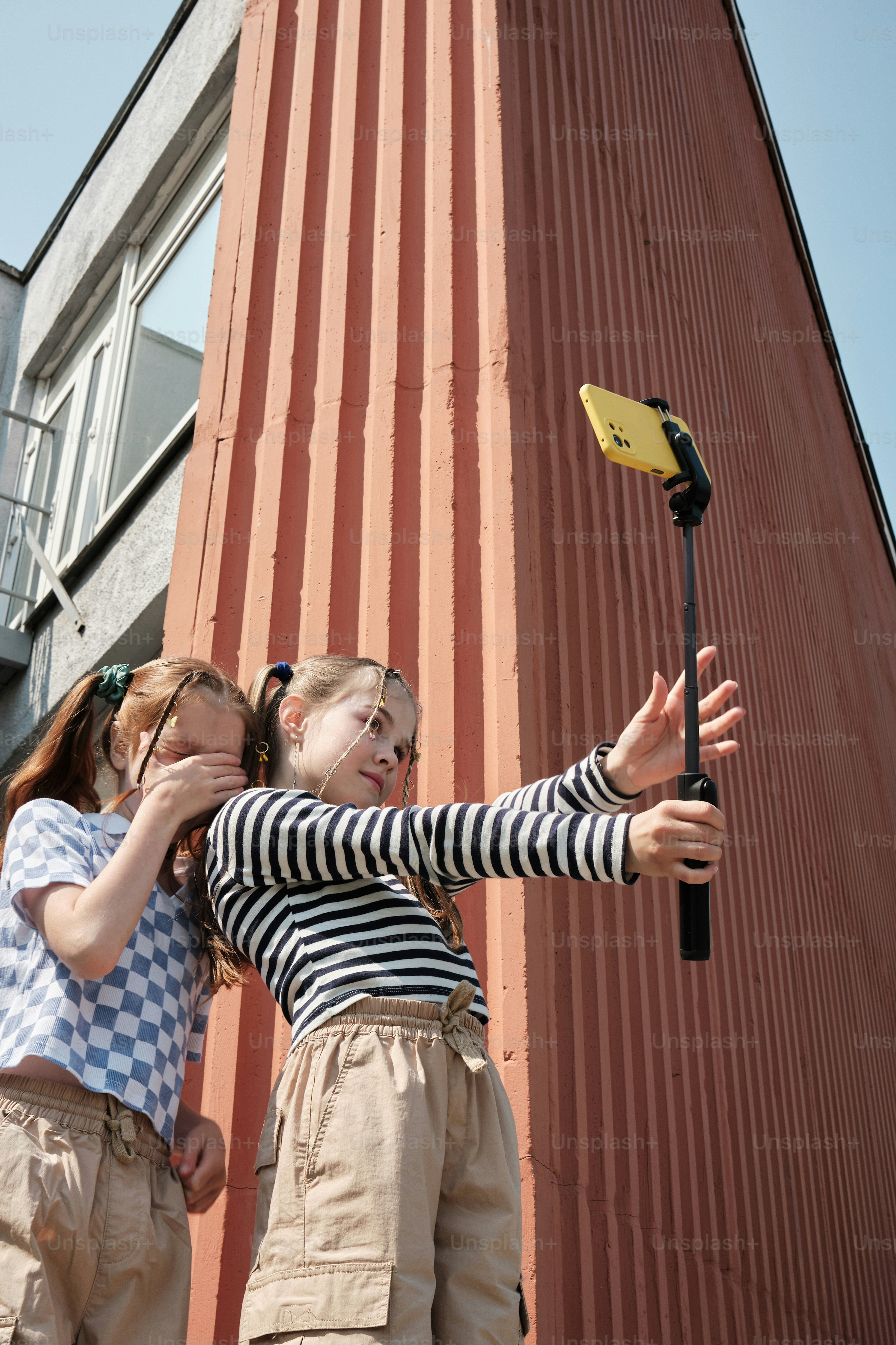 a couple of kids standing next to a tall building