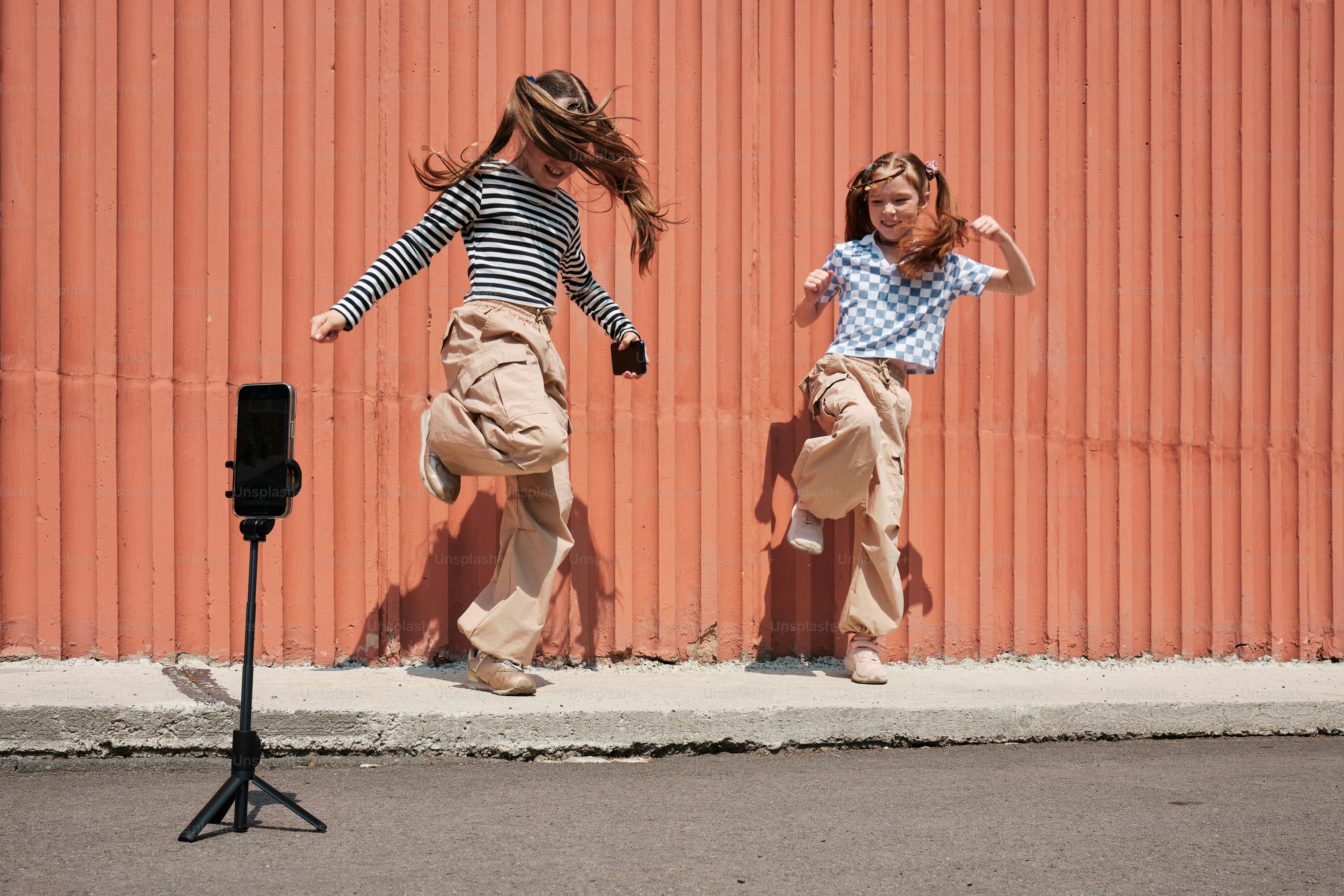 two young girls dancing in front of a camera