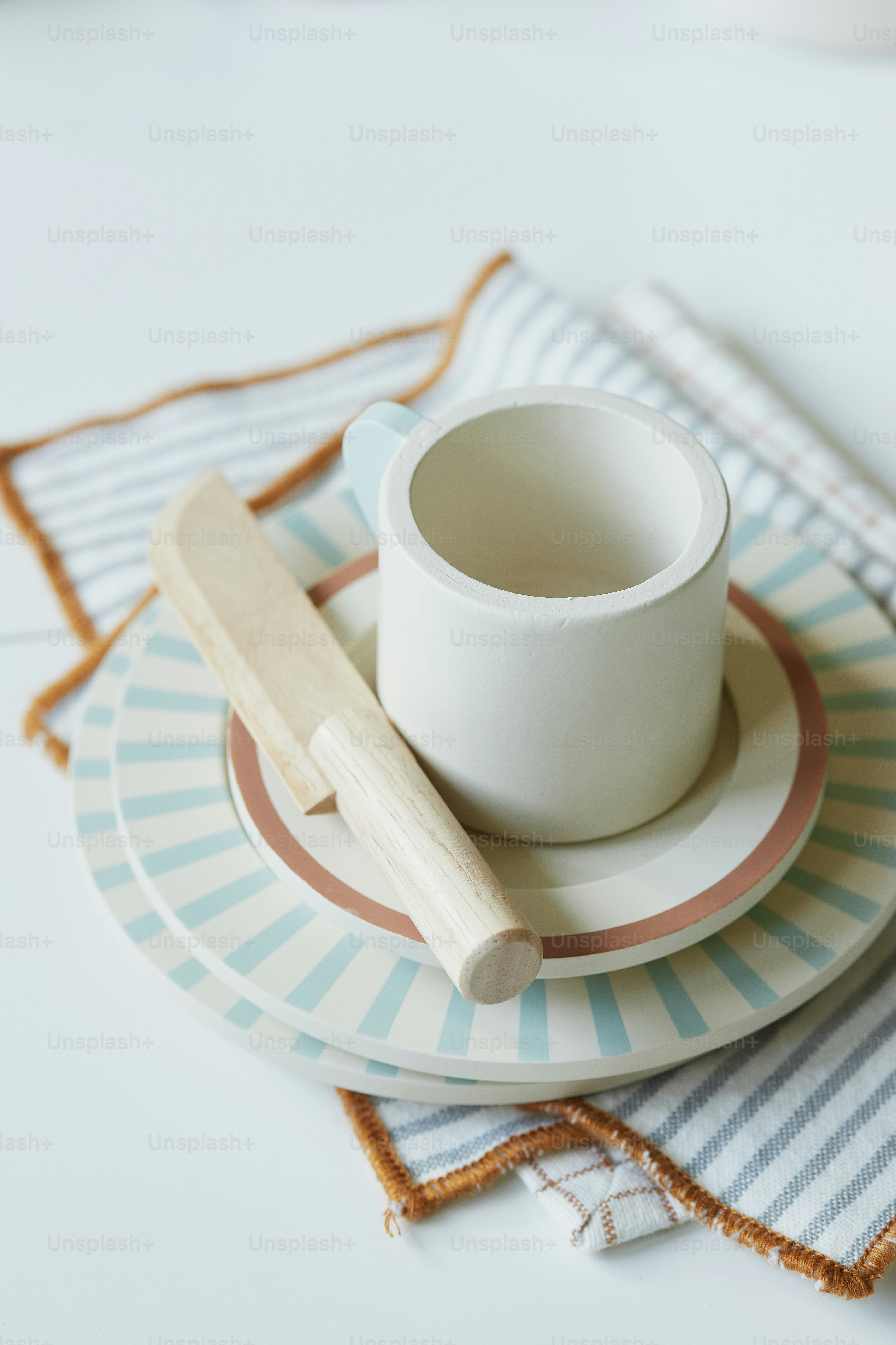 a cup on a plate with a wooden spoon