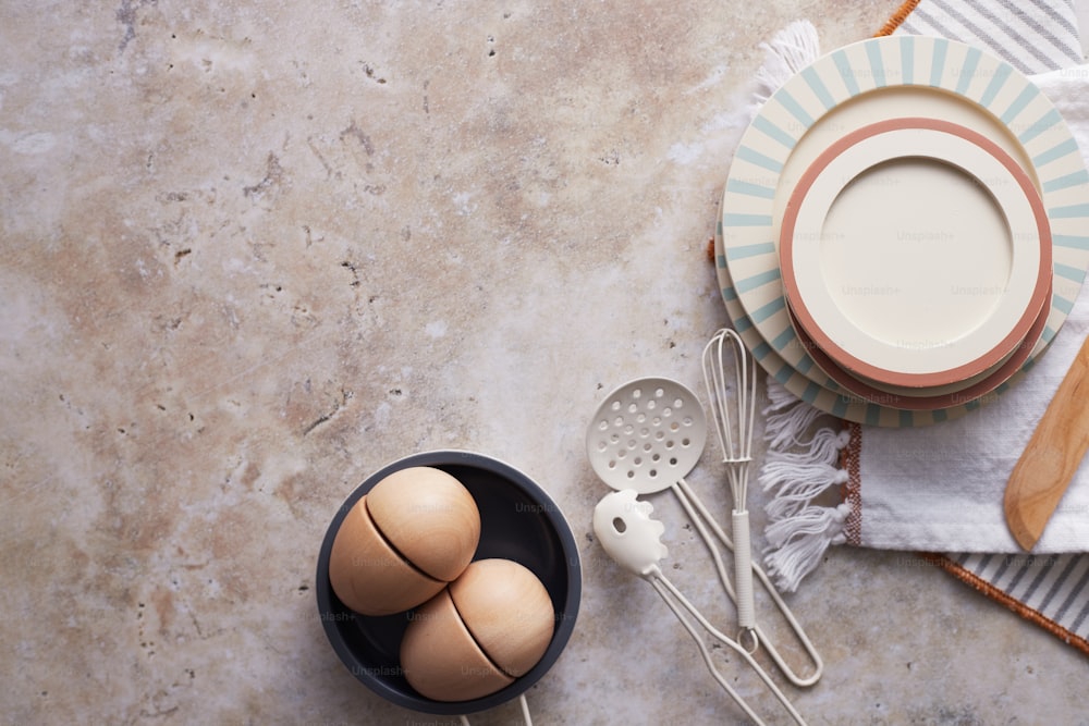 a table topped with a bowl of eggs and utensils