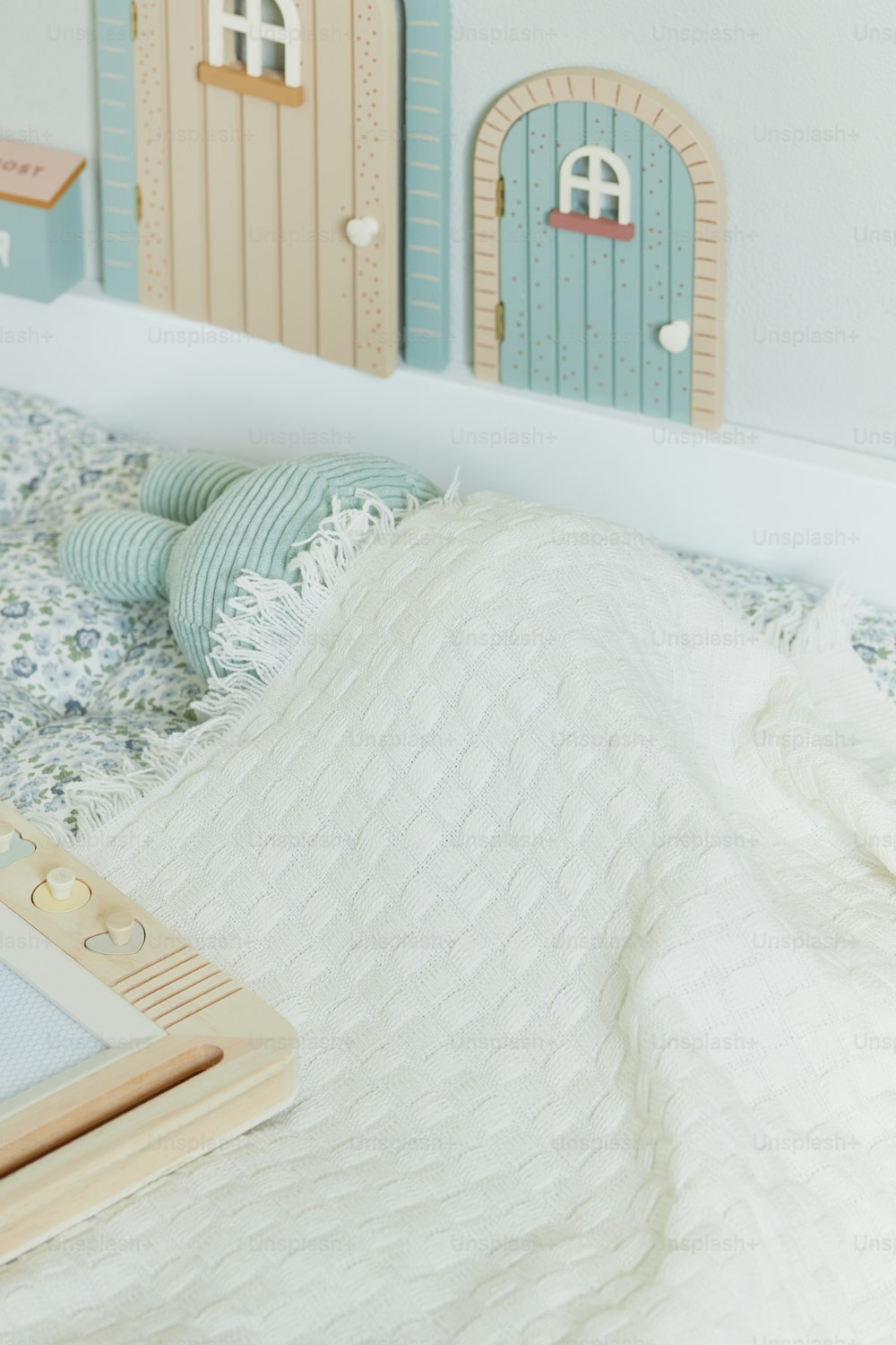 uma cama com um cobertor branco e uma porta azul