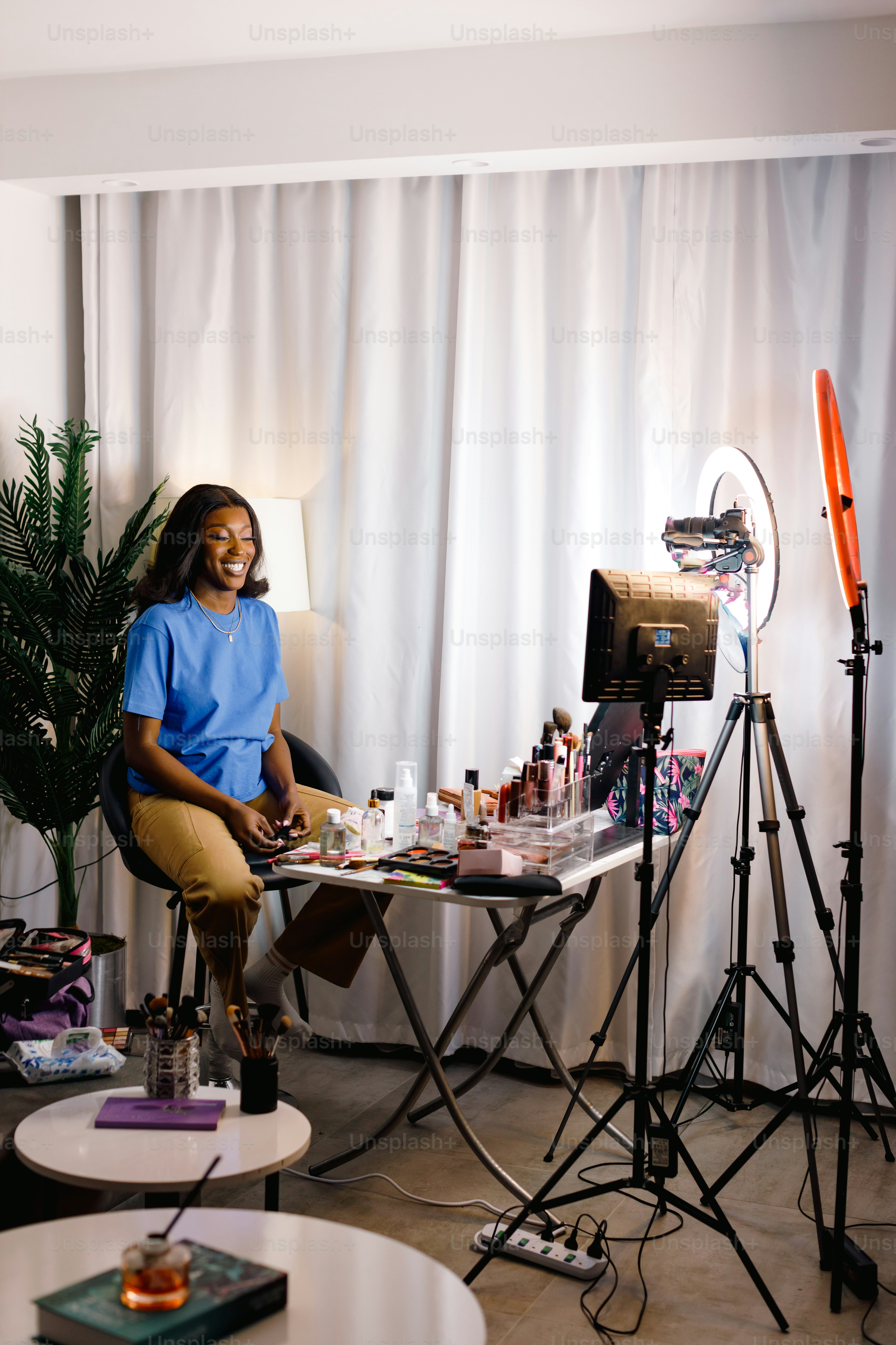a woman sitting at a table in front of a camera