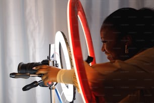 Una mujer tomando una foto de una cámara en un trípode