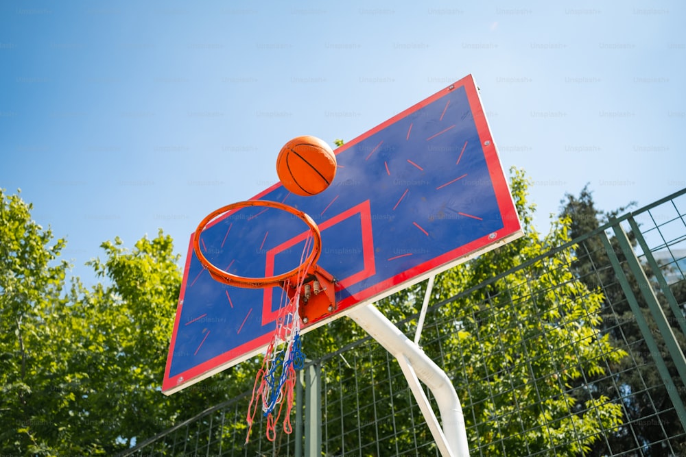 a blue and red basketball hoop with a basketball on it