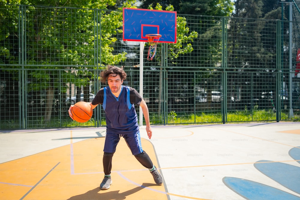 a young man holding a basketball while standing on a basketball court