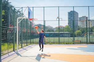 Un hombre está jugando baloncesto en una cancha