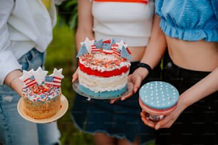two people holding a cake with red, white and blue decorations