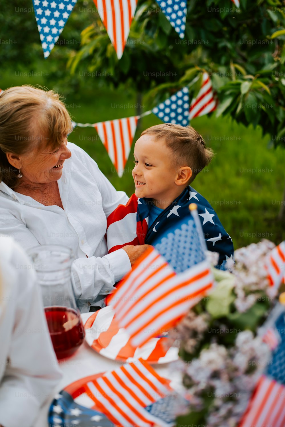 Uma mulher e uma criança sentadas em uma mesa com bandeiras americanas