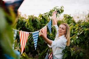 Una mujer sosteniendo banderas estadounidenses en un campo