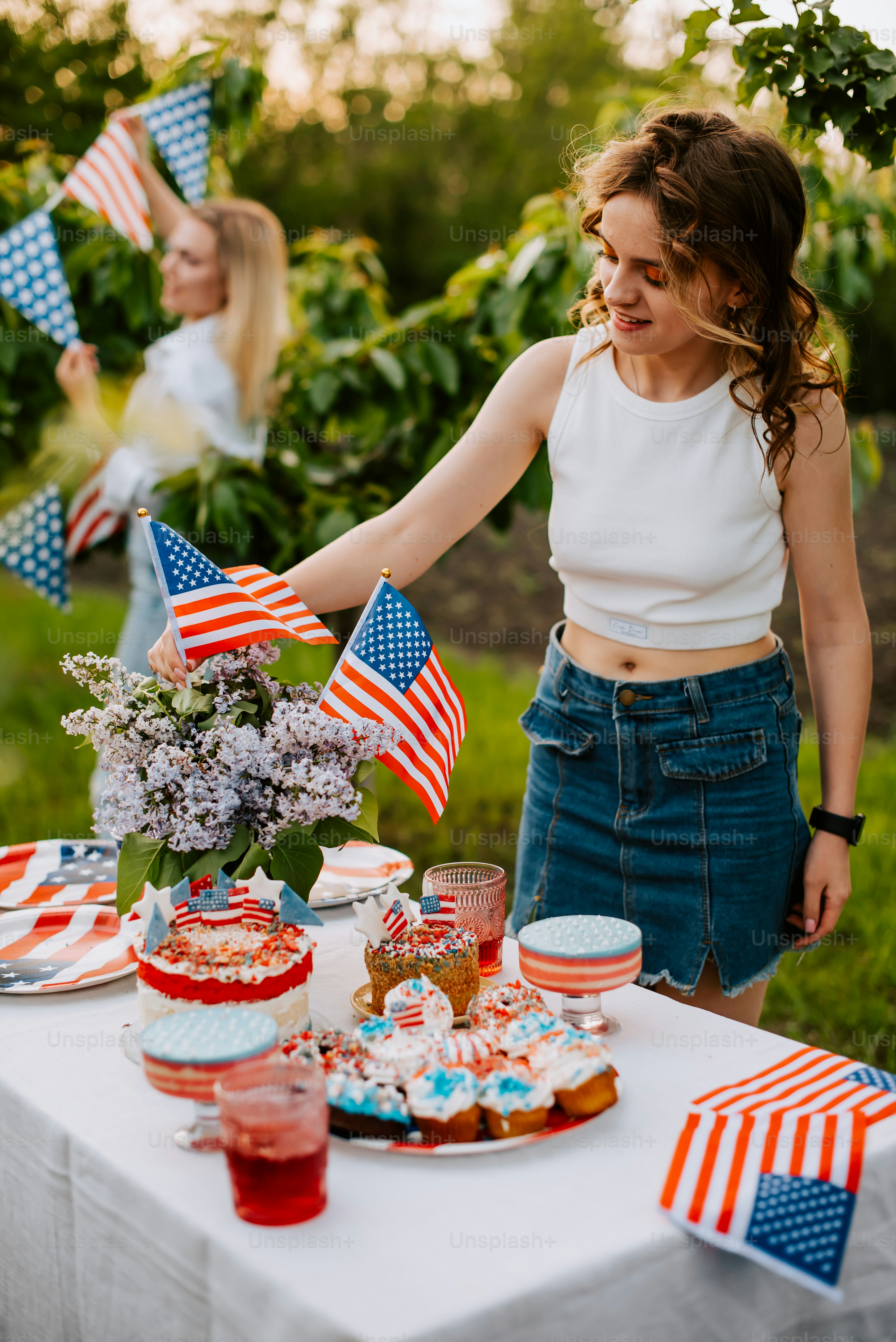 eine frau, die neben einem tisch mit desserts gefüllt steht