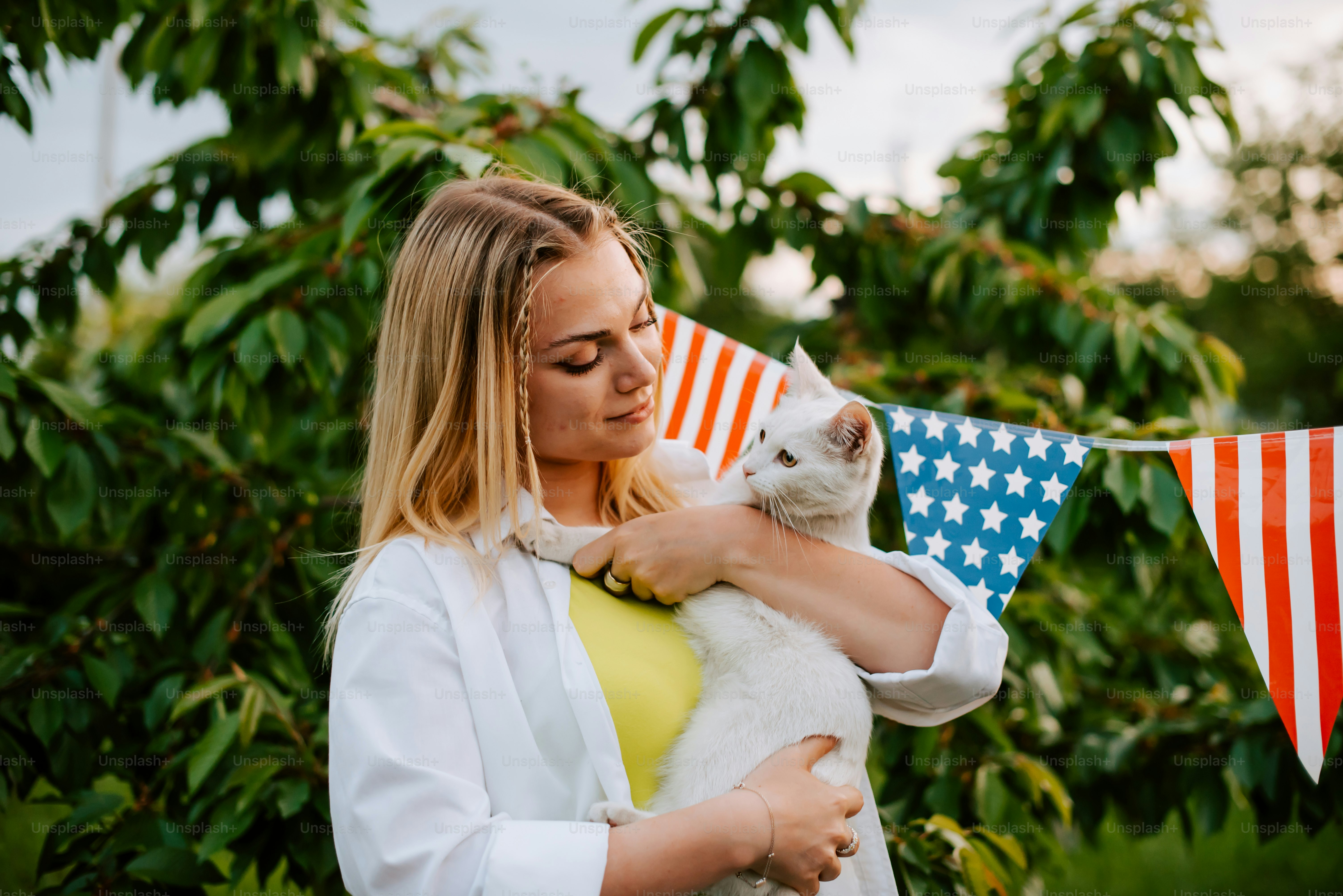 eine frau, die eine weiße katze in ihren armen hält