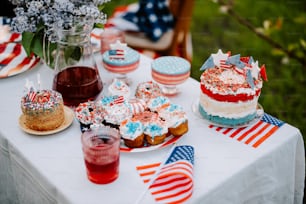 a table topped with cakes and desserts covered in red, white, and blue