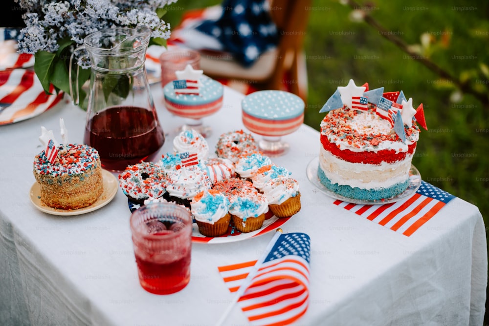 a table topped with cakes and desserts covered in red, white, and blue