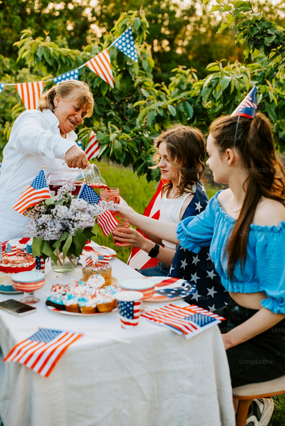 Un grupo de mujeres sentadas alrededor de una mesa con banderas estadounidenses