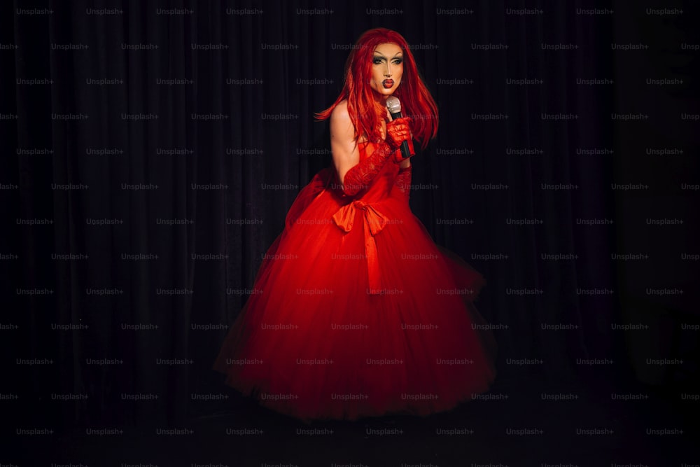 uma mulher em um vestido vermelho segurando um microfone
