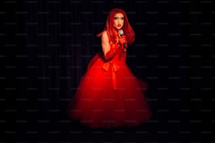 Una donna in un vestito rosso che tiene un microfono