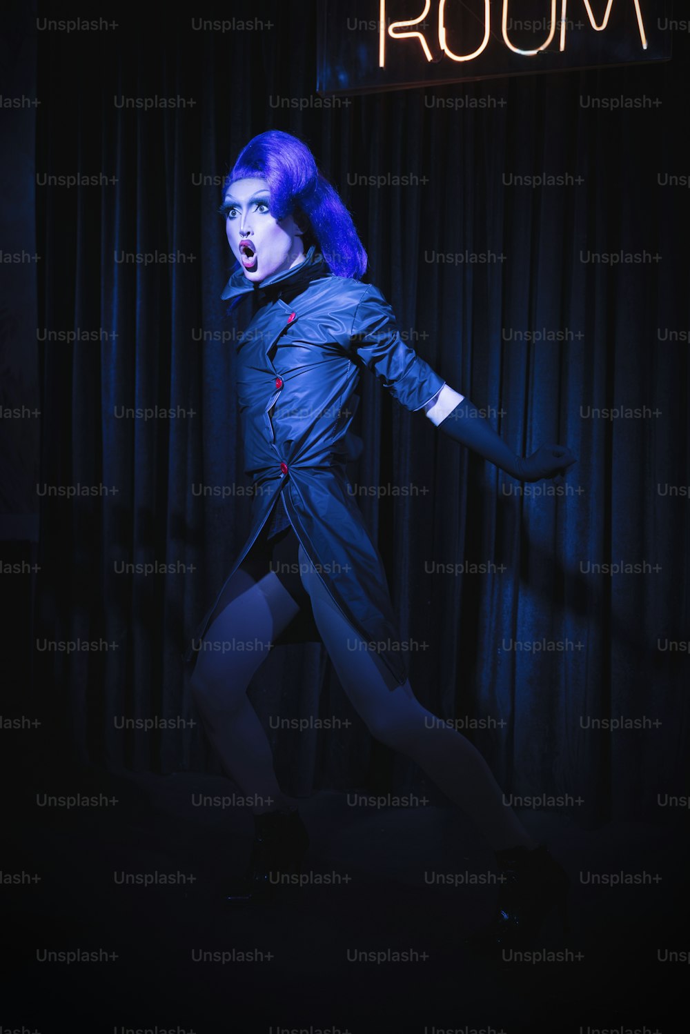 a woman with purple hair is posing in a dark room