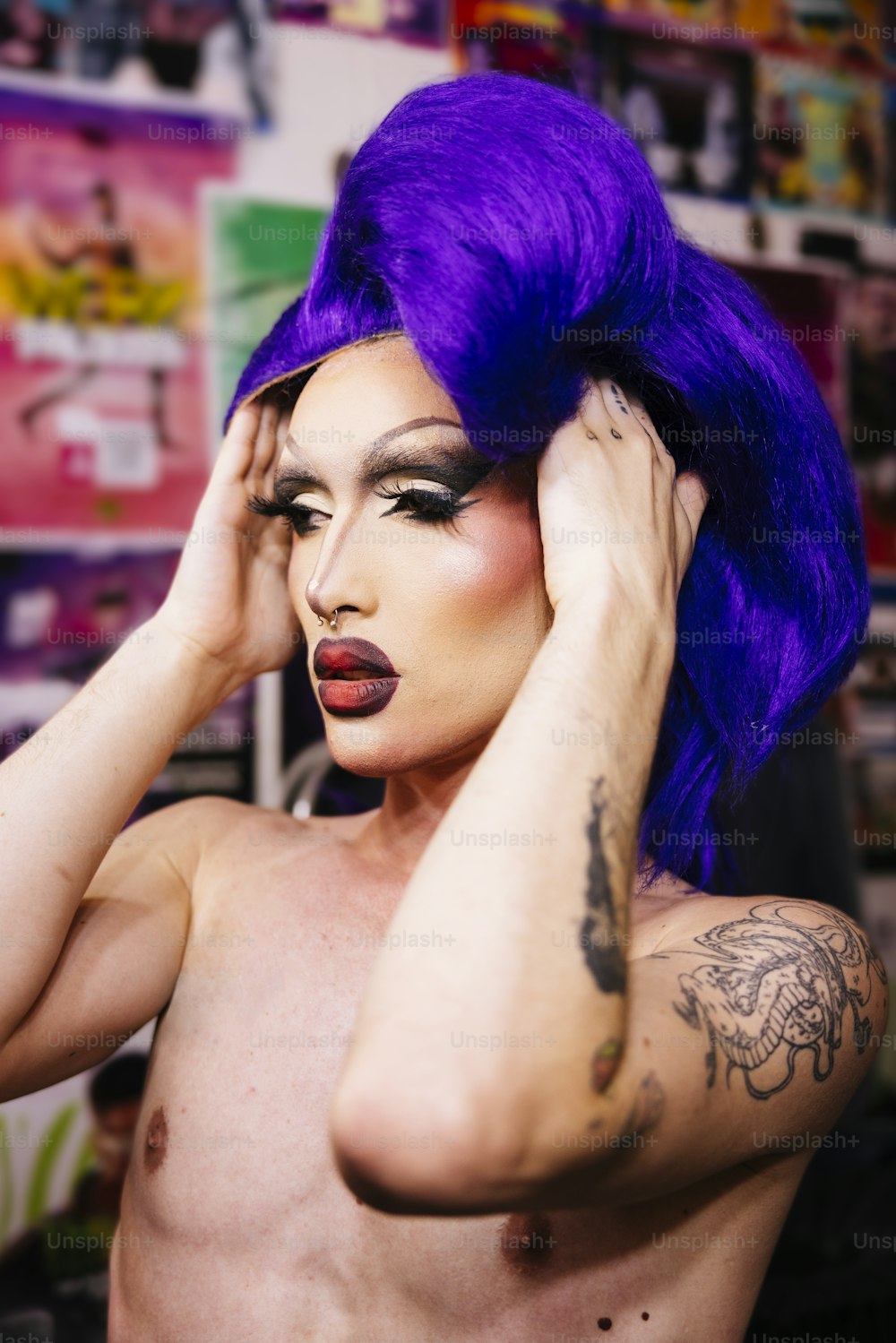 Une femme aux cheveux violets et aux tatouages tenant sa tête