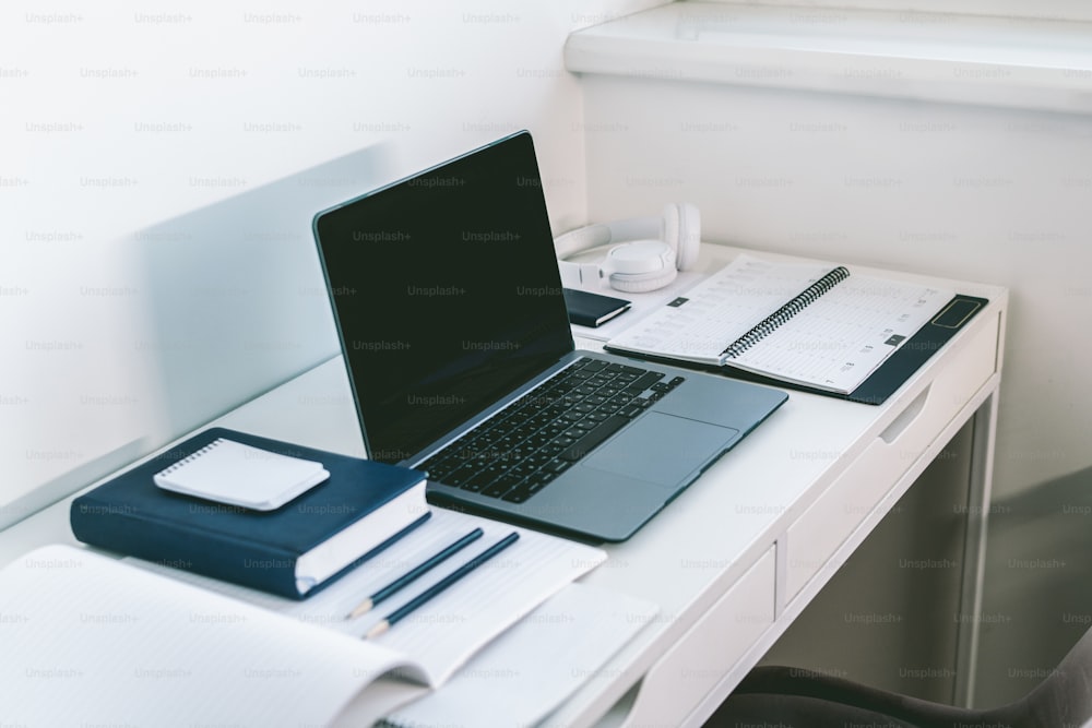 a laptop computer sitting on top of a white desk