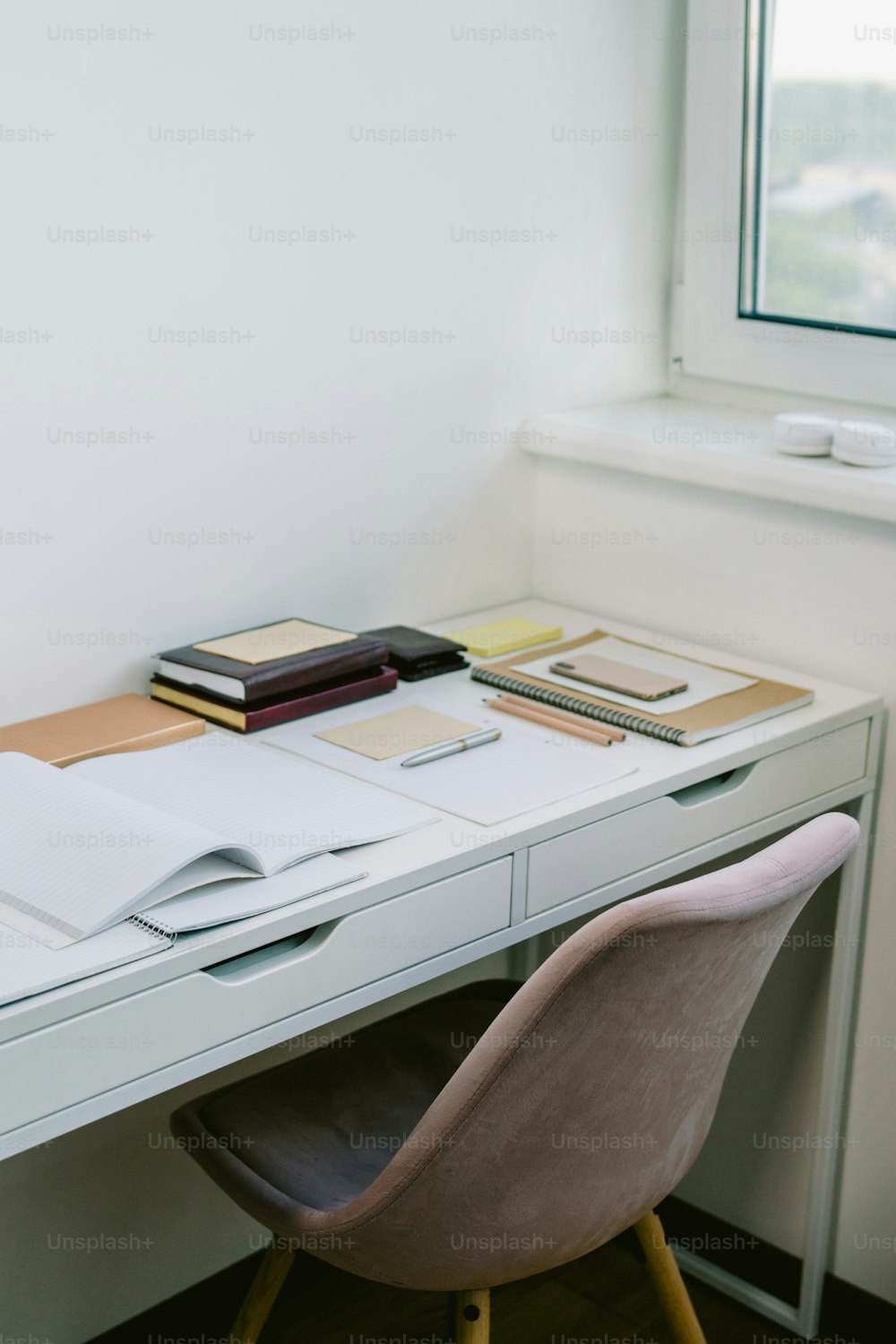 a white desk topped with a laptop computer next to a window