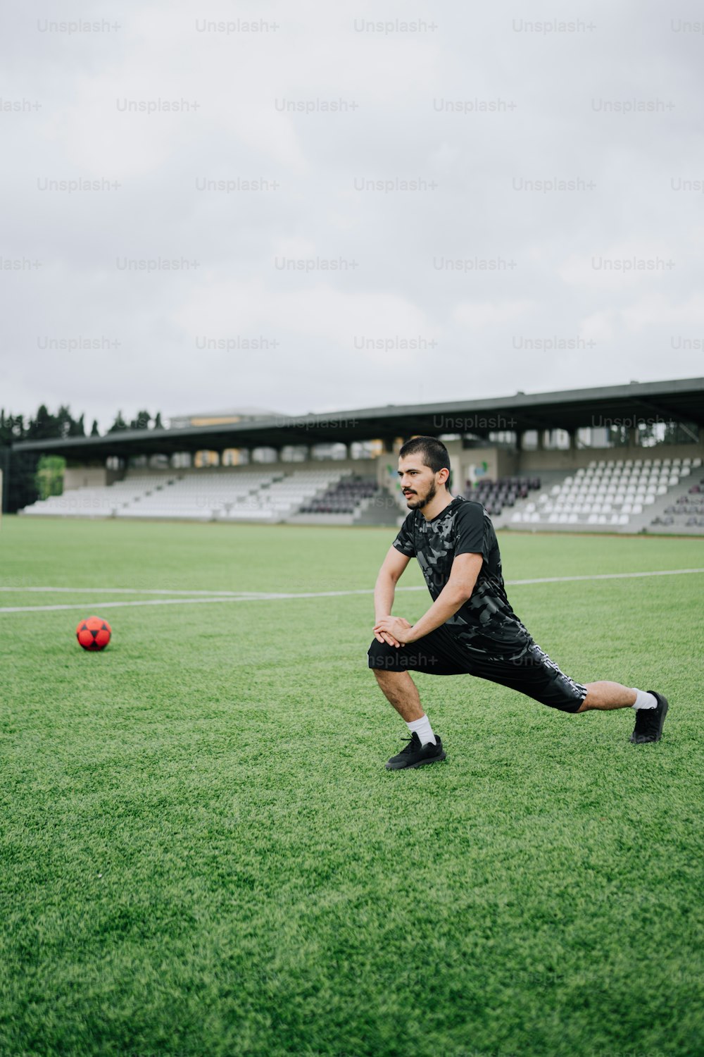 a man in black shirt and shorts playing a game of frisbee