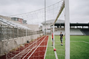 una porta da calcio con un portiere in piedi accanto ad esso