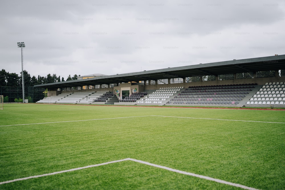 a soccer field with empty bleachers on a cloudy day