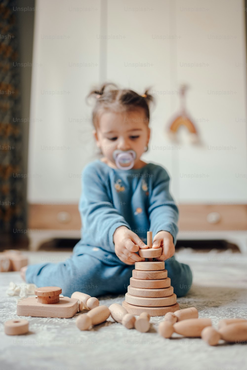 a baby playing with a stack of wooden blocks