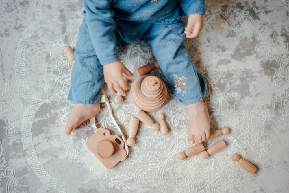 Un bambino che gioca con giocattoli di legno sul pavimento