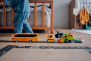 un área de juegos para niños con un autobús de juguete y vehículos de construcción