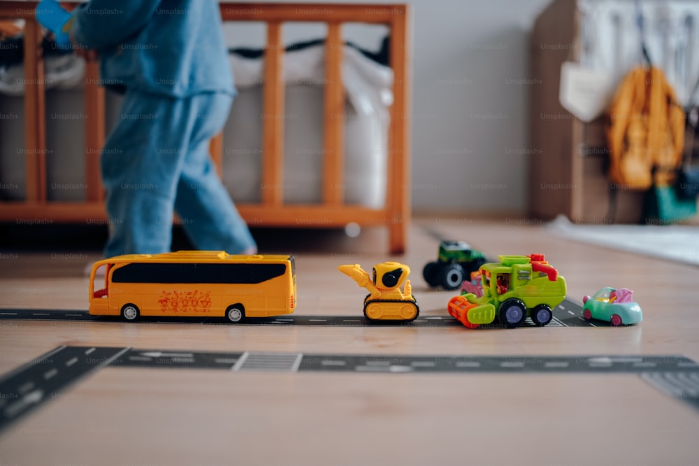 a child's play area with a toy bus and construction vehicles