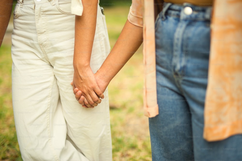 a close up of two people holding hands