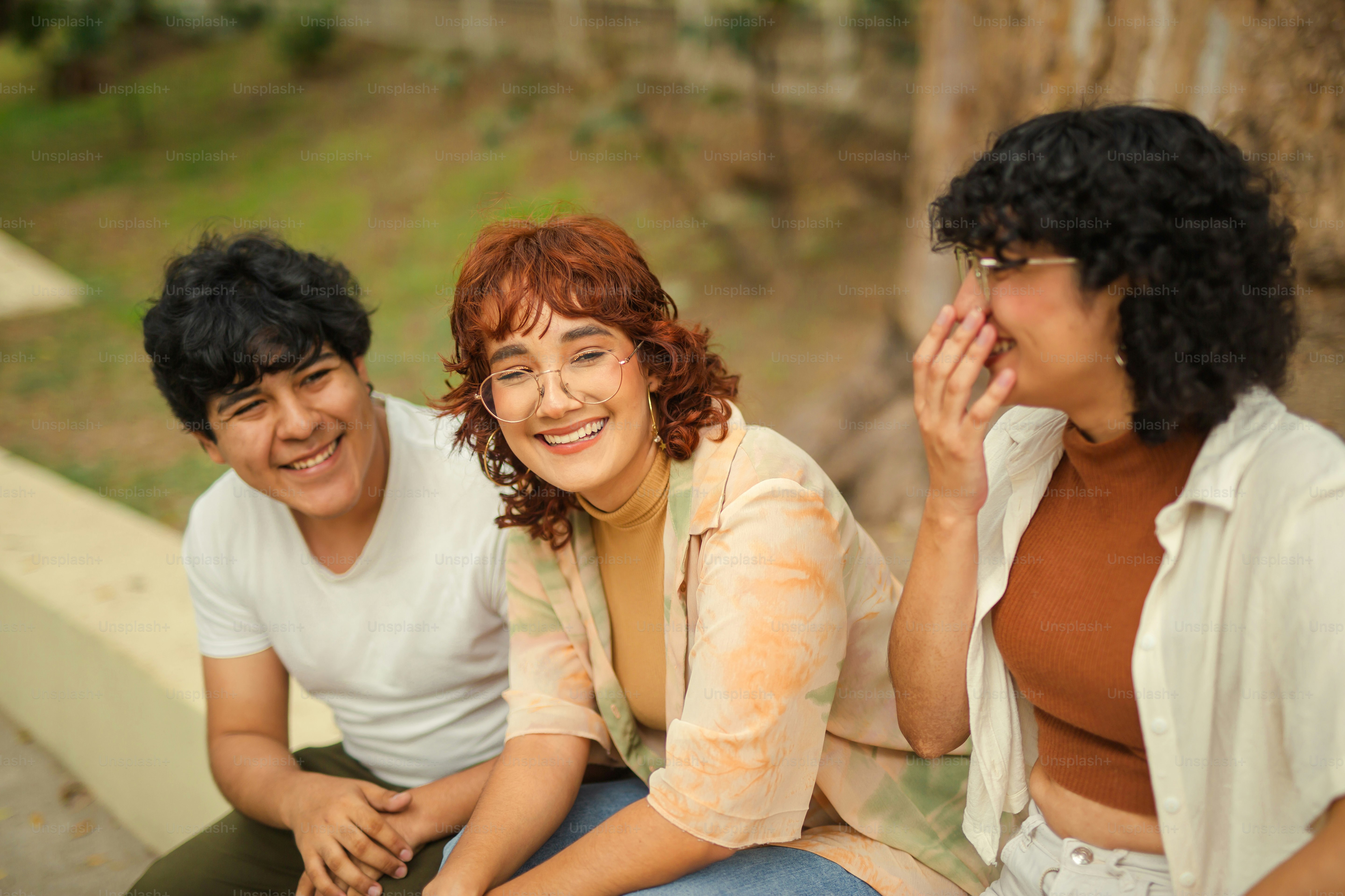 A group of three people sitting next to each other photo – Diversity ...