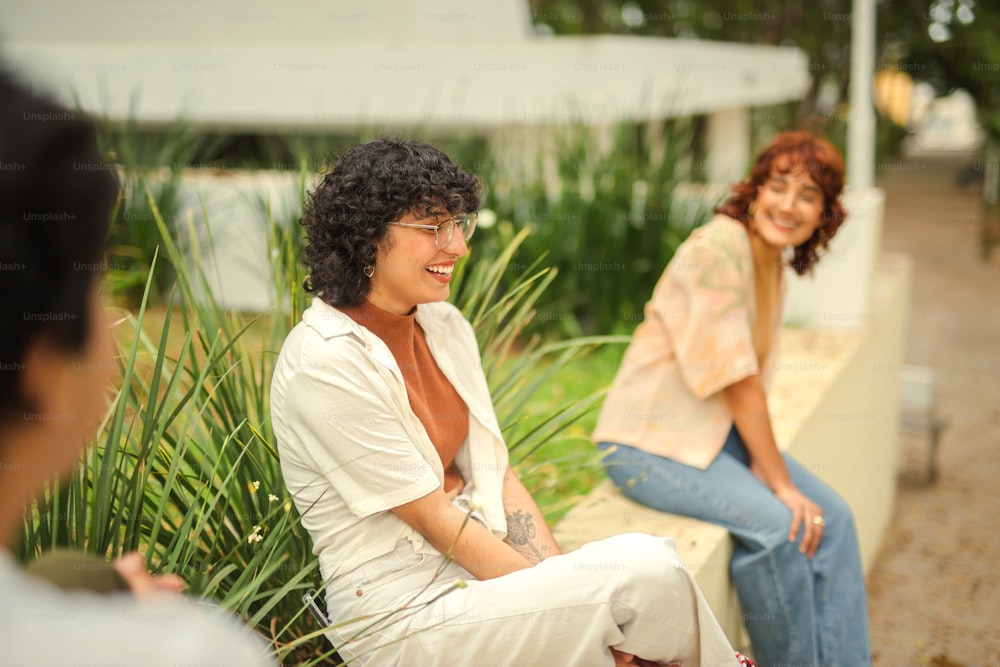 a woman sitting on a bench next to another woman