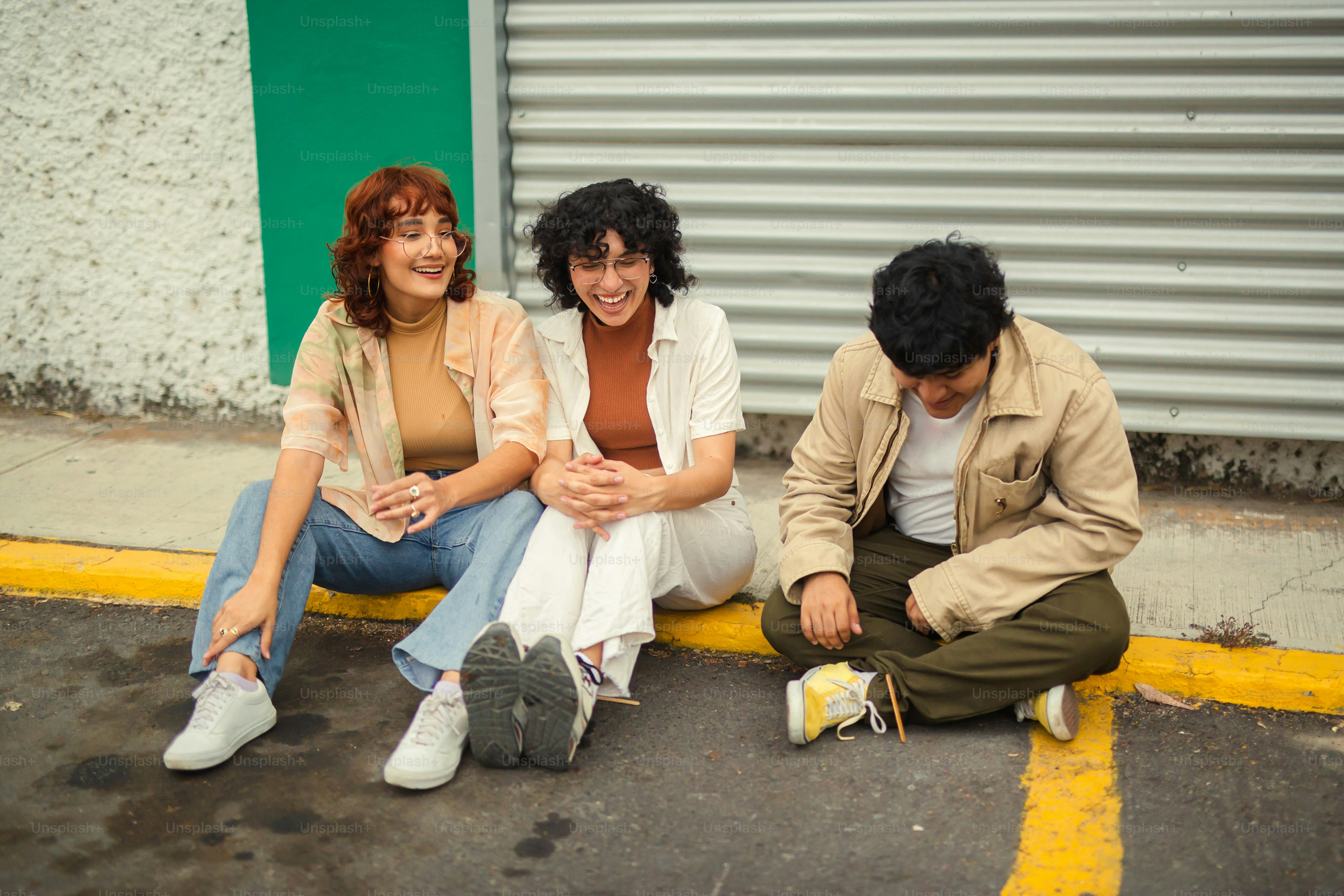 a group of people sitting on the side of a road