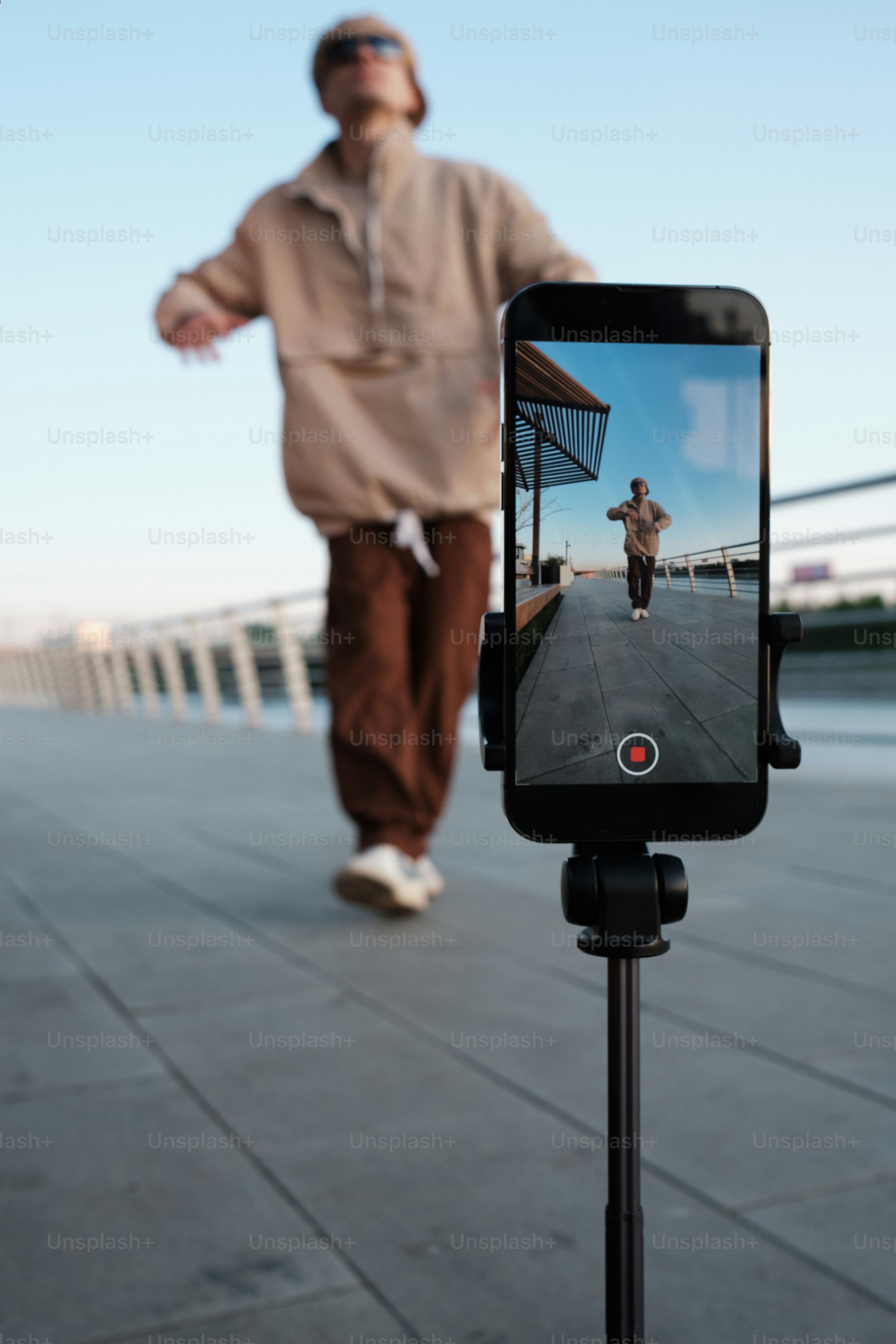 ein mann, der neben einem handy einen bürgersteig hinuntergeht