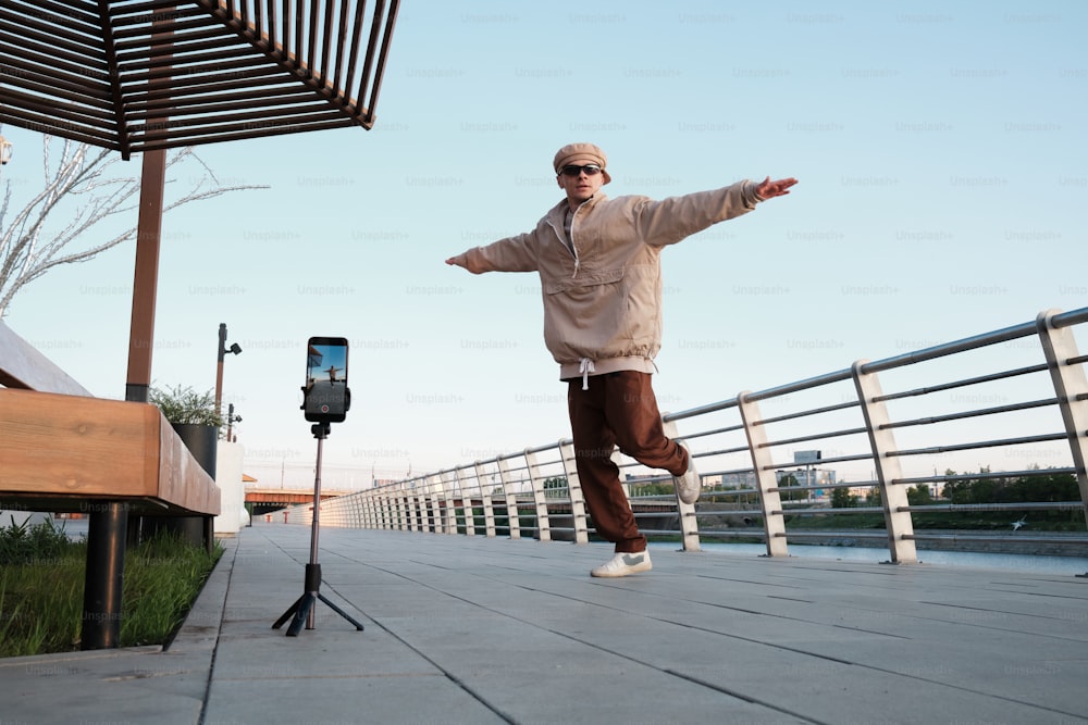 a man standing on a sidewalk with his arms outstretched