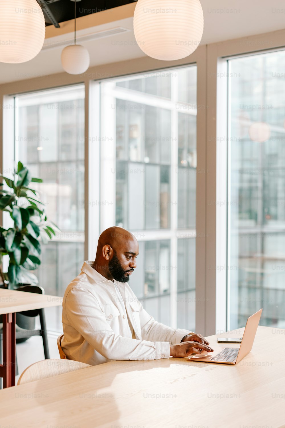 a man sitting at a table using a laptop computer