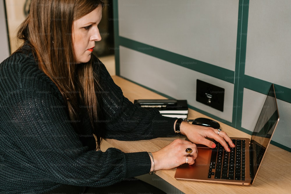 노트북 컴퓨터를 사용하여 책��상에 앉아 있는 여자