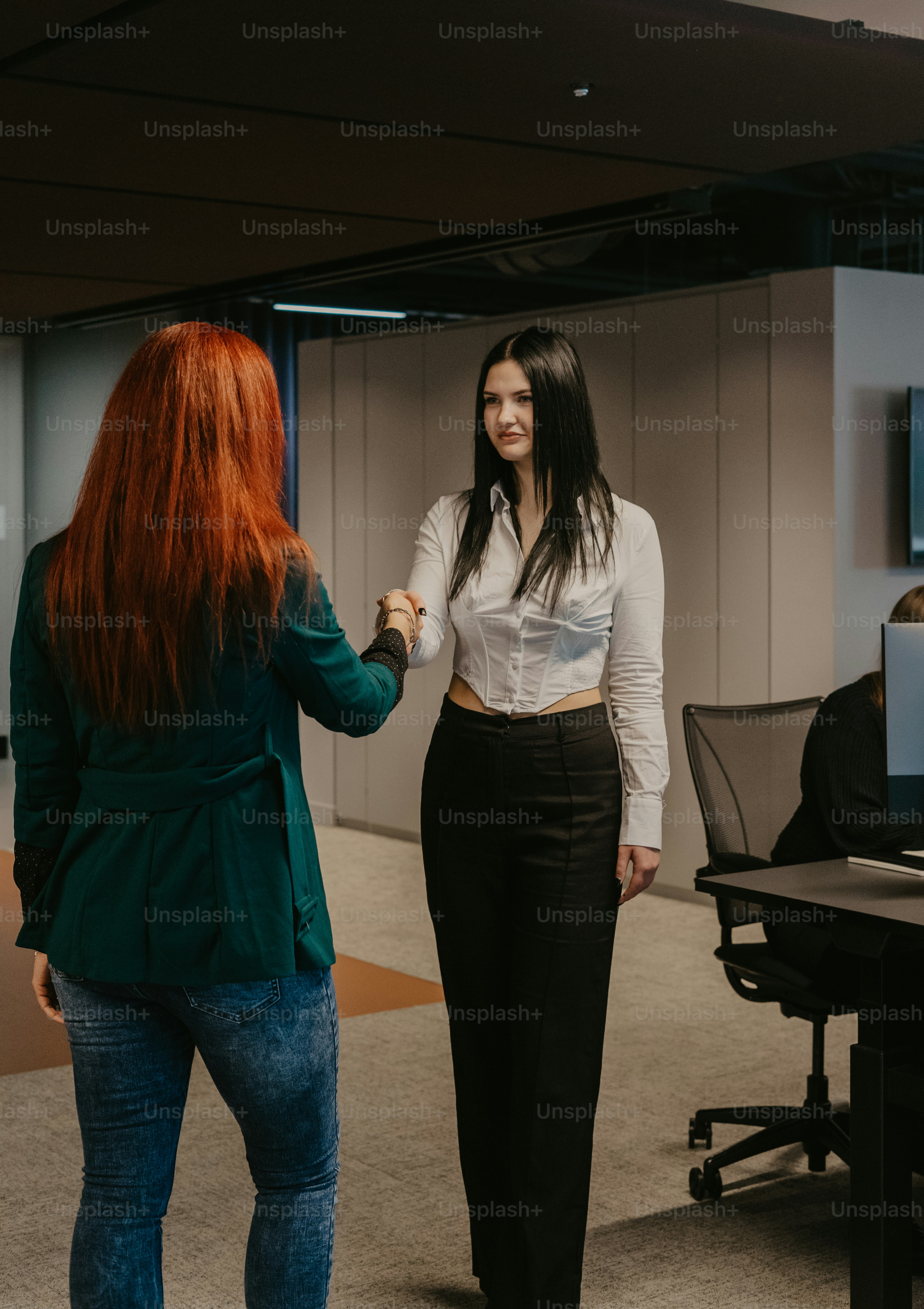 a woman standing next to another woman in a room