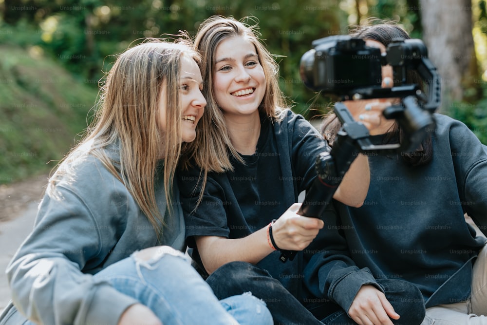 two women sitting on the ground with a camera