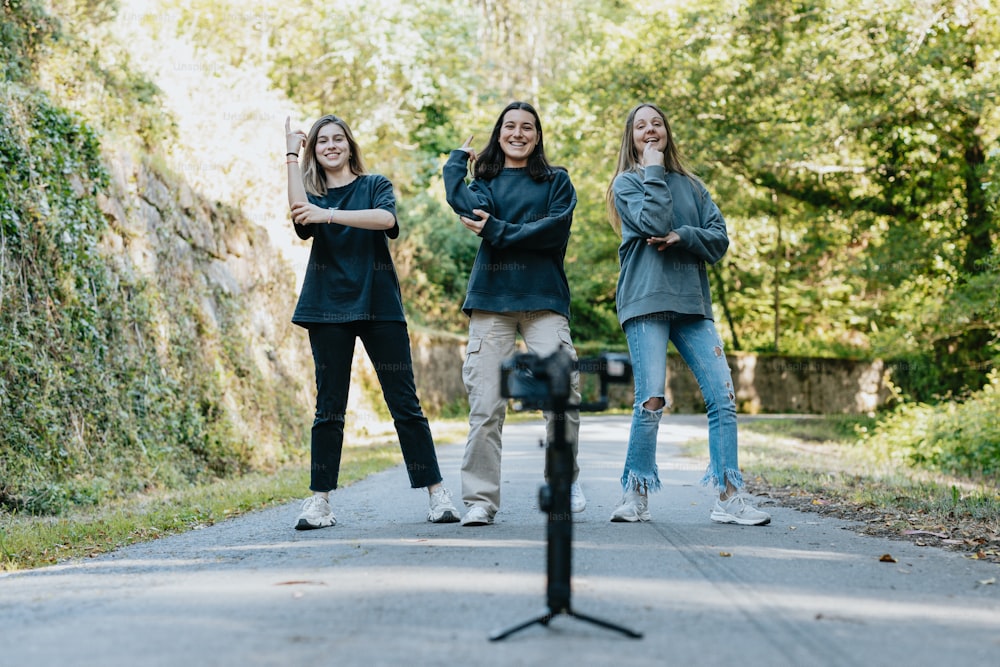 a group of three women standing next to a parking meter