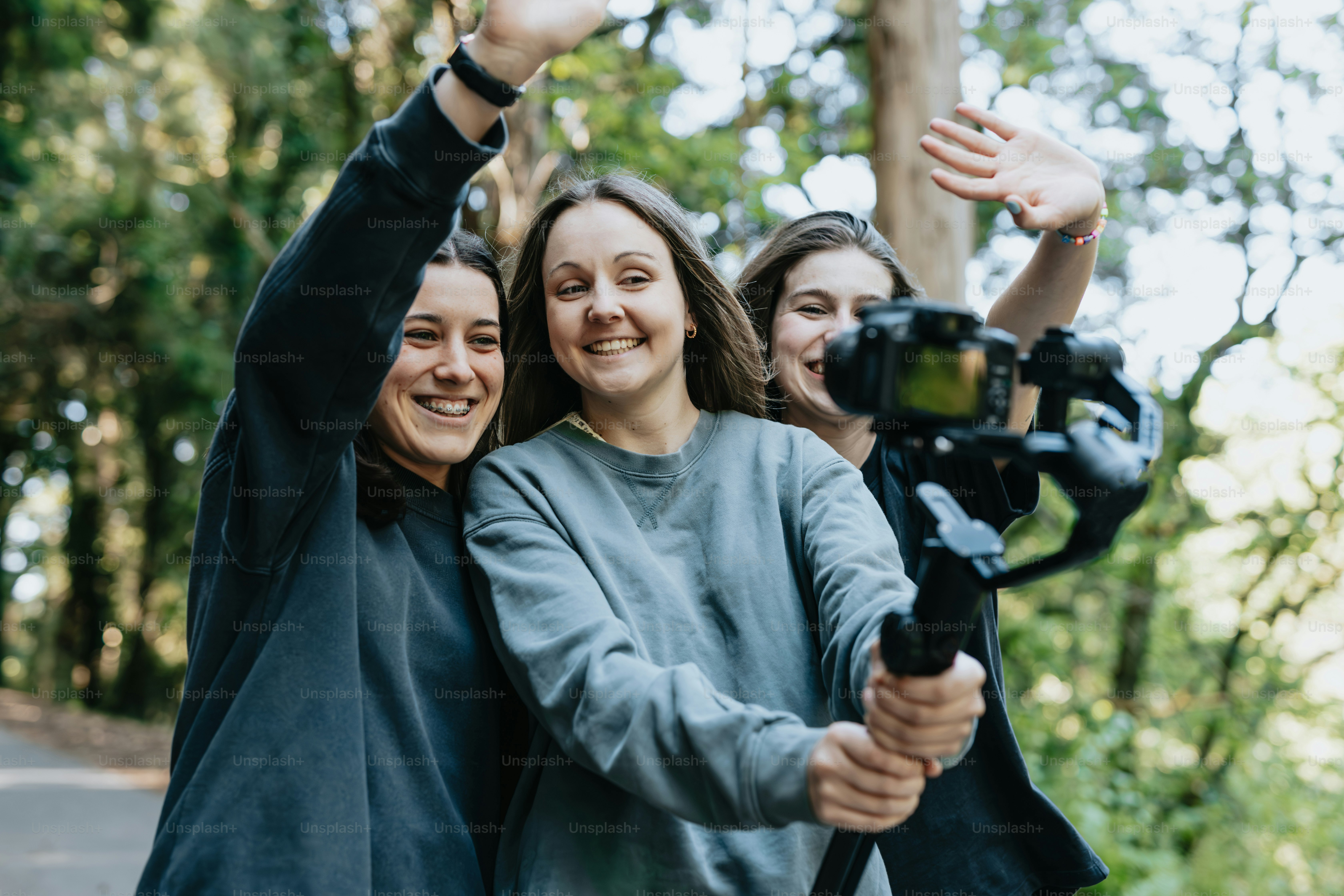 a group of women standing next to each other holding a camera