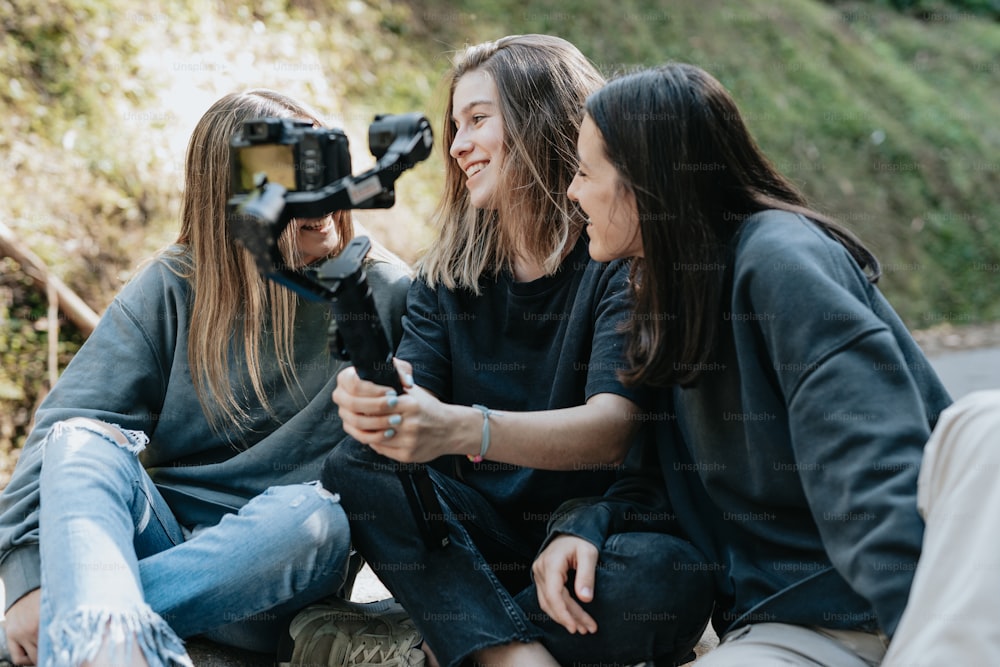 Trois femmes assises par terre avec une caméra