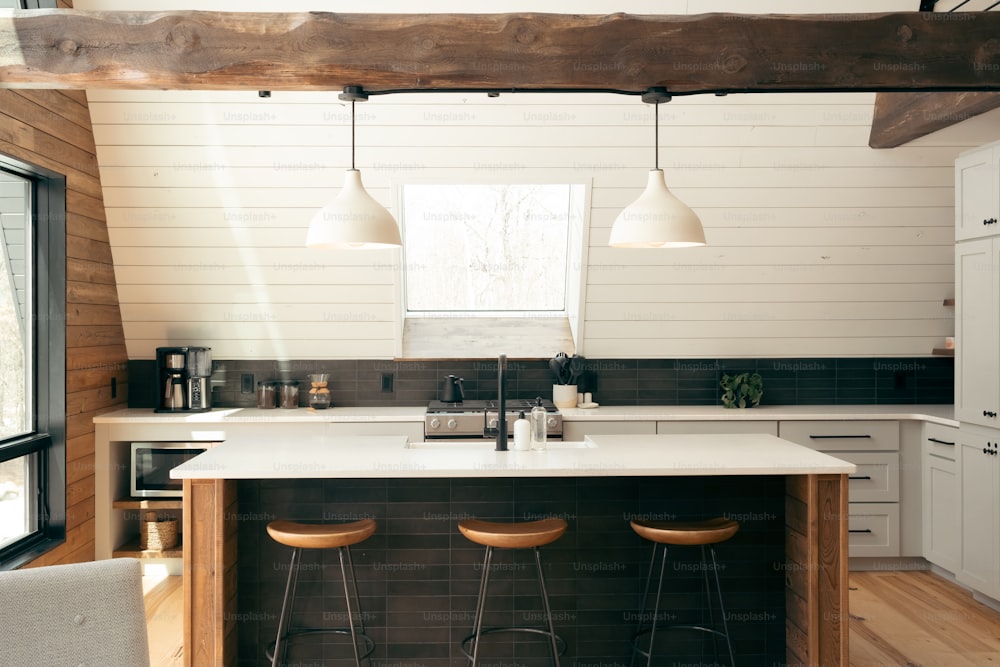 a kitchen with three stools and a center island