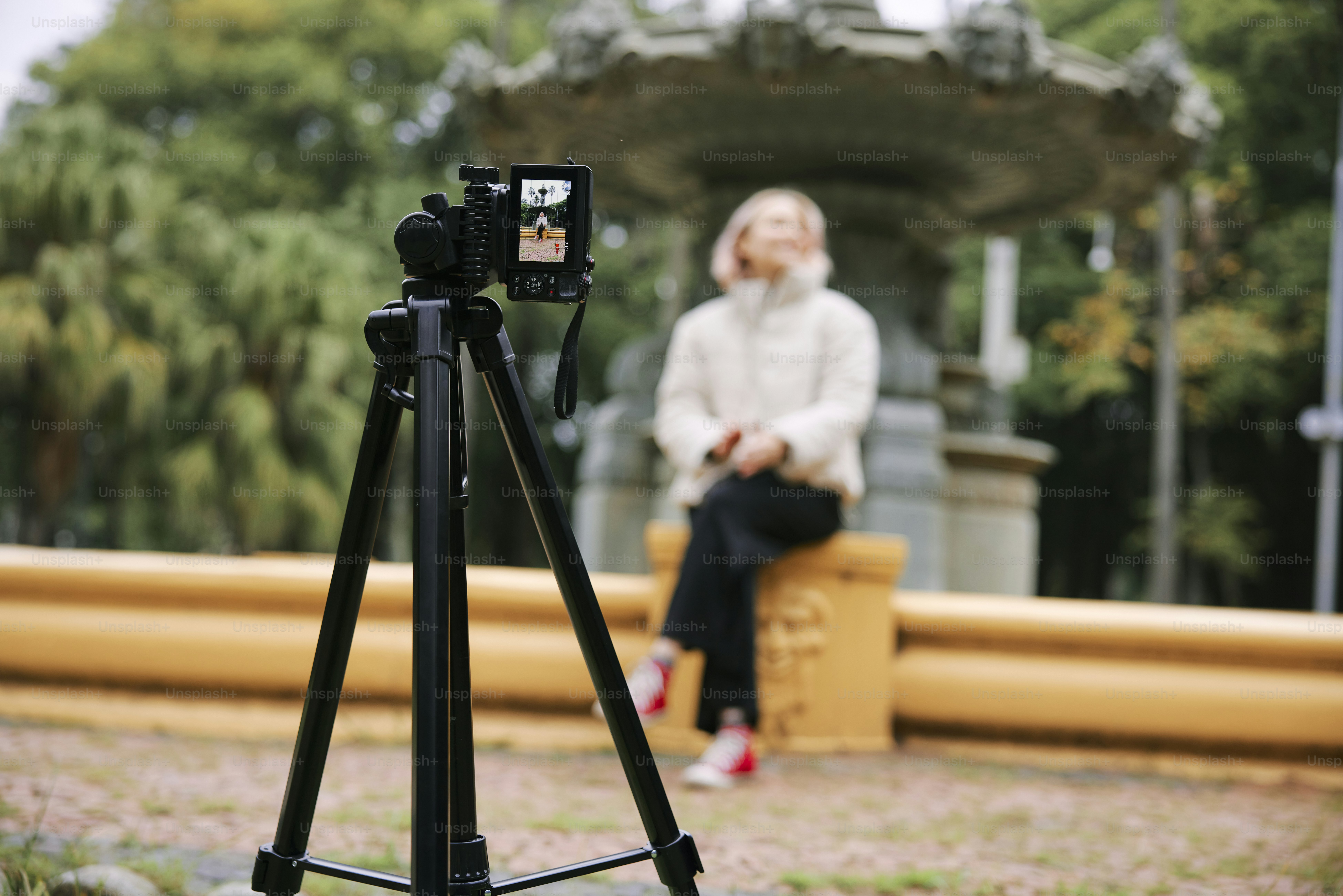 a woman sitting on a bench next to a camera