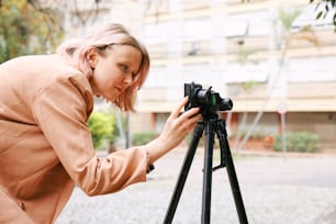 a woman taking a picture with a camera on a tripod